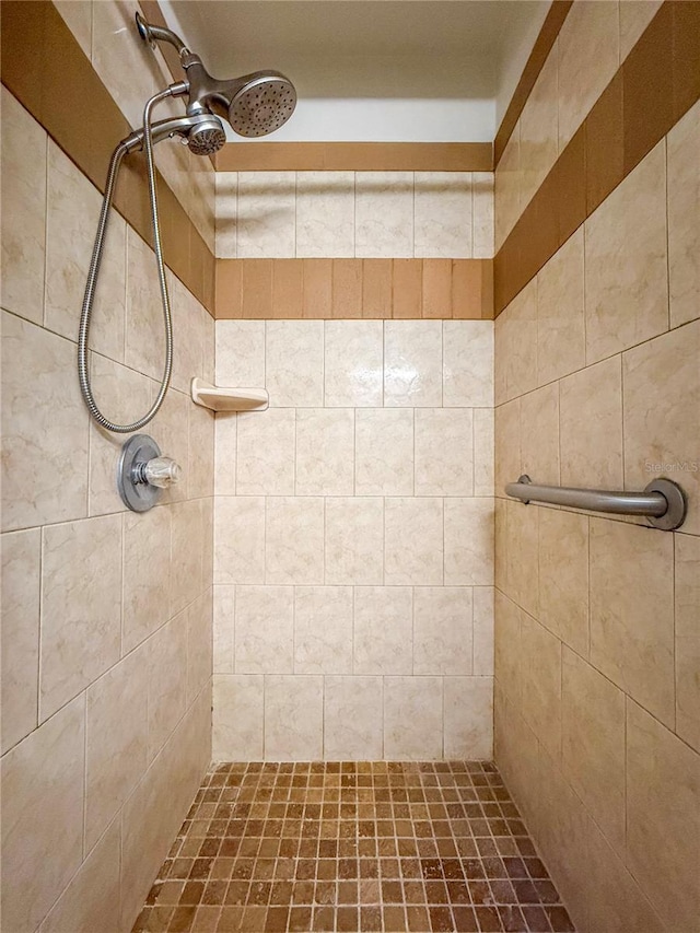 bathroom with a ceiling fan and tiled shower