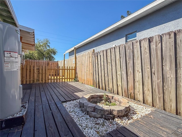wooden terrace with an outdoor fire pit and fence