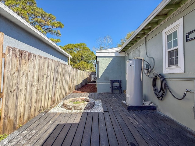 wooden terrace featuring water heater and fence