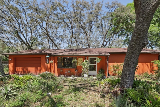 view of front of house with stucco siding and a garage