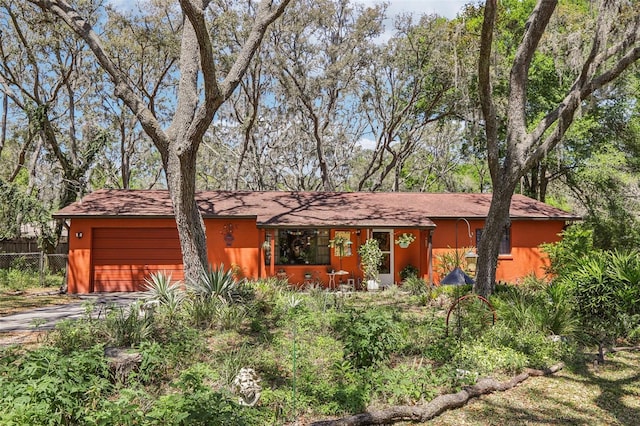ranch-style house with fence, driveway, and a garage