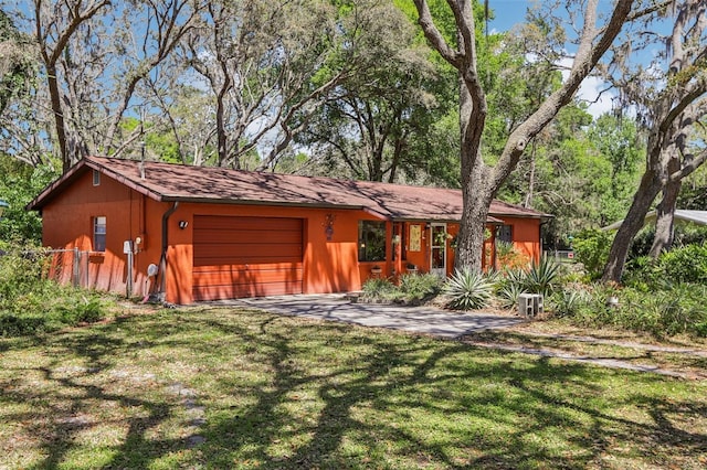 view of front of house featuring driveway, a garage, and a front lawn