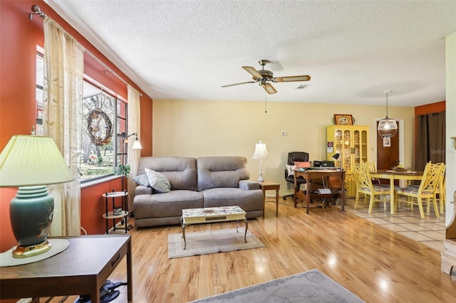 living area with wood finished floors, ceiling fan, and a textured ceiling