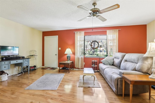 living area featuring a textured ceiling, ceiling fan, and wood finished floors