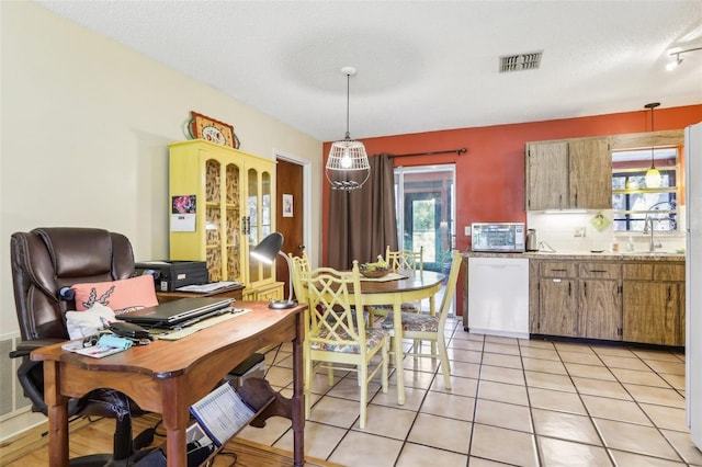 interior space with a textured ceiling, visible vents, light tile patterned floors, and plenty of natural light