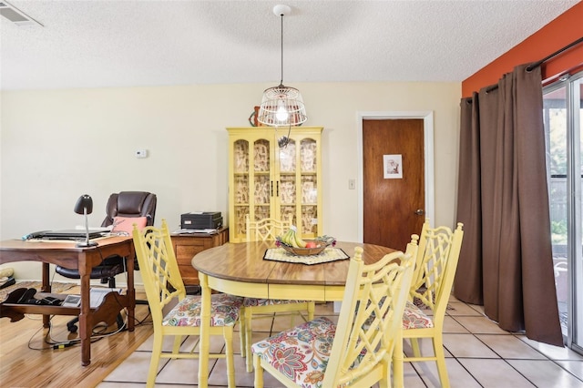 dining space with a textured ceiling and visible vents