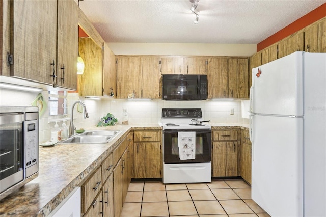 kitchen with a sink, electric range oven, black microwave, freestanding refrigerator, and stainless steel microwave