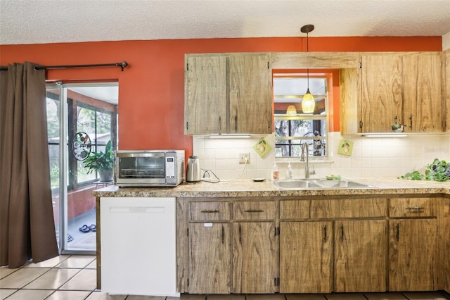 kitchen featuring light tile patterned flooring, backsplash, a sink, a textured ceiling, and white dishwasher