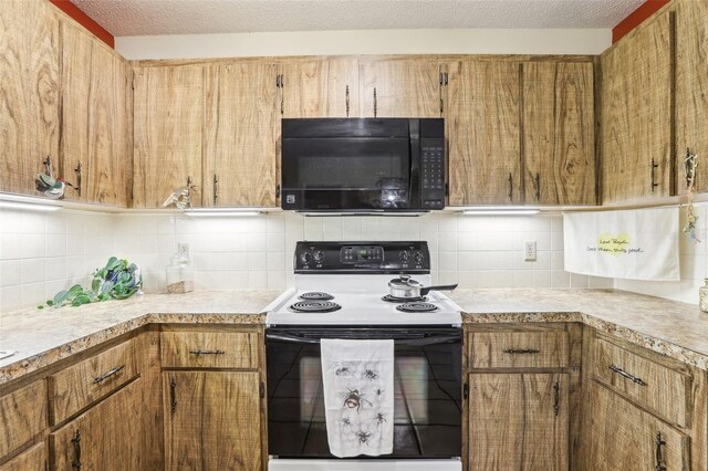 kitchen featuring black microwave, electric stove, light countertops, and backsplash