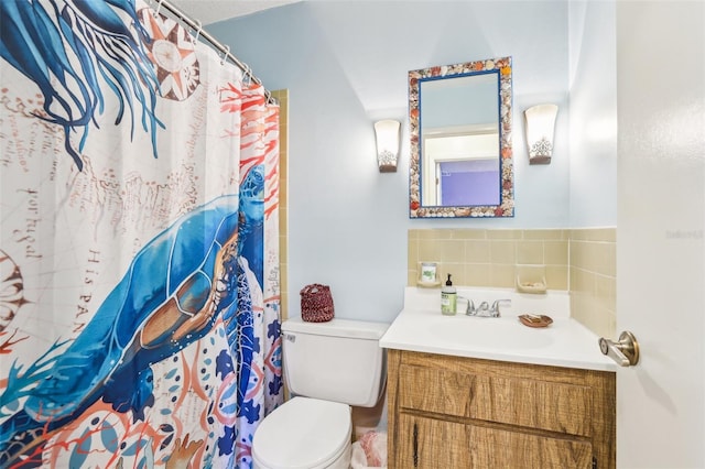 bathroom featuring toilet, vanity, and a shower with curtain