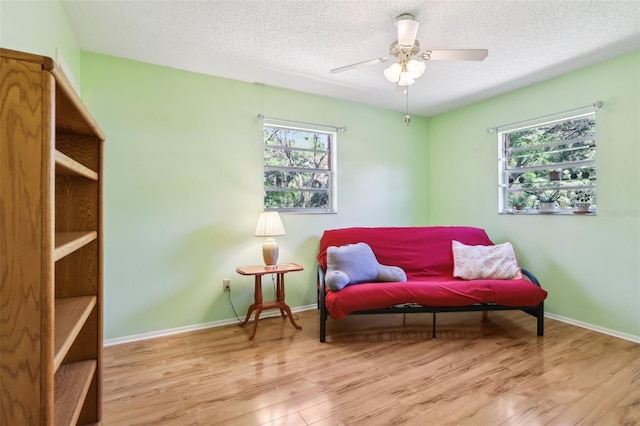 living area featuring a wealth of natural light, a textured ceiling, and wood finished floors