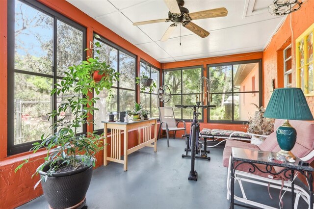 sunroom / solarium featuring an outdoor hangout area, a ceiling fan, and finished concrete floors