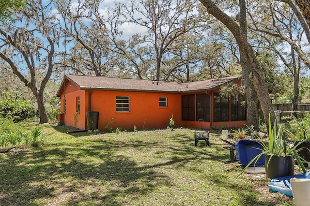 back of property with a sunroom, fence, and a yard