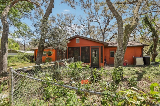 rear view of property with a sunroom and central AC
