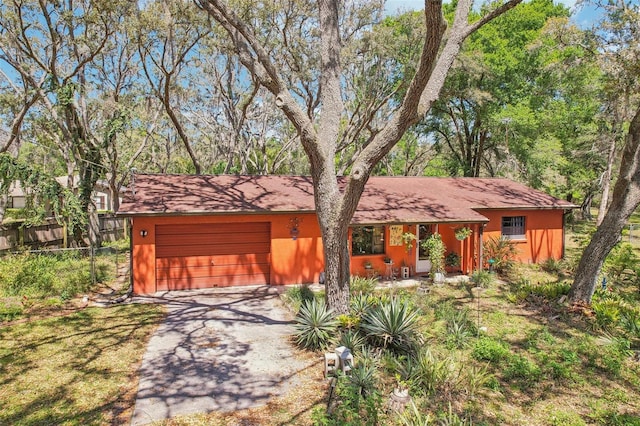 view of front of property featuring aphalt driveway, fence, and an attached garage