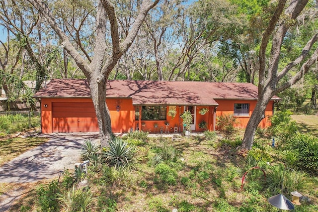 ranch-style house featuring fence, a garage, and aphalt driveway
