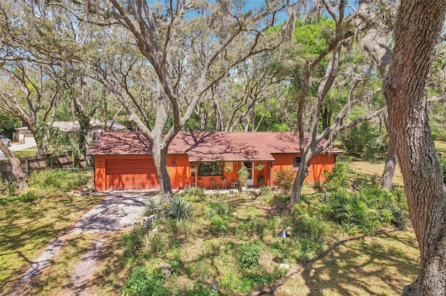 view of front of property featuring driveway, an attached garage, and fence