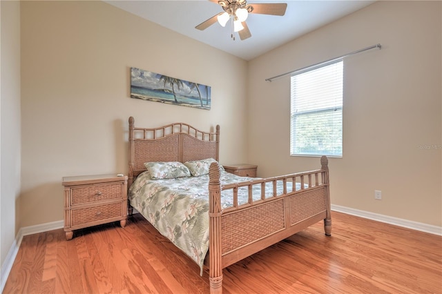 bedroom with baseboards, a ceiling fan, and light wood-style flooring