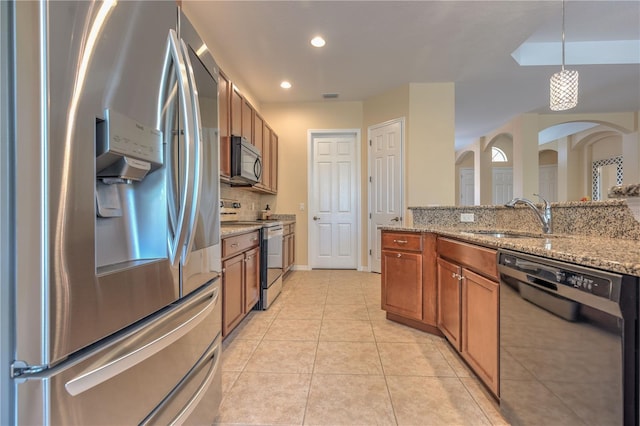 2218 132nd Pl E, Parrish, FL 34219 - kitchen with stainless steel fridge with ice dispenser, dishwasher, range with electric cooktop, a sink, and brown cabinets