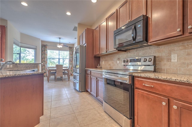 2218 132nd Pl E, Parrish, FL 34219 - kitchen with a ceiling fan, light stone countertops, light tile patterned floors, a sink, and appliances with stainless steel finishes