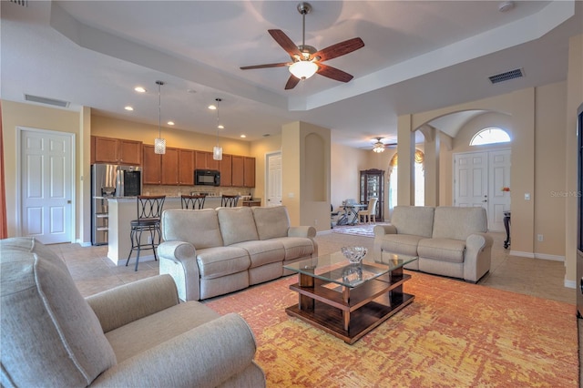 2218 132nd Pl E, Parrish, FL 34219 - living area featuring a ceiling fan, a tray ceiling, recessed lighting, light tile patterned flooring, and arched walkways