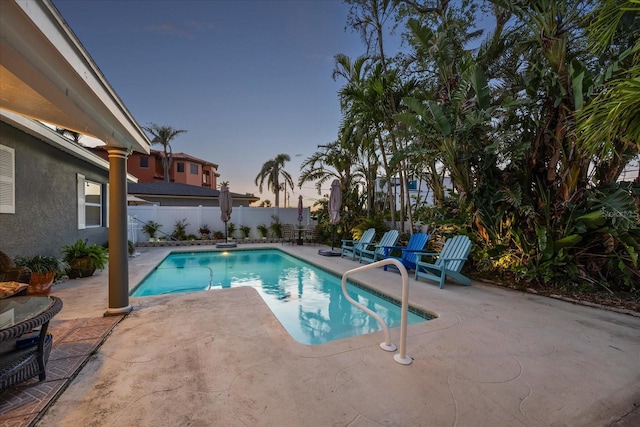7912 3rd Ave S, Saint Petersburg, FL 33707 - pool at dusk featuring a patio and a fenced backyard