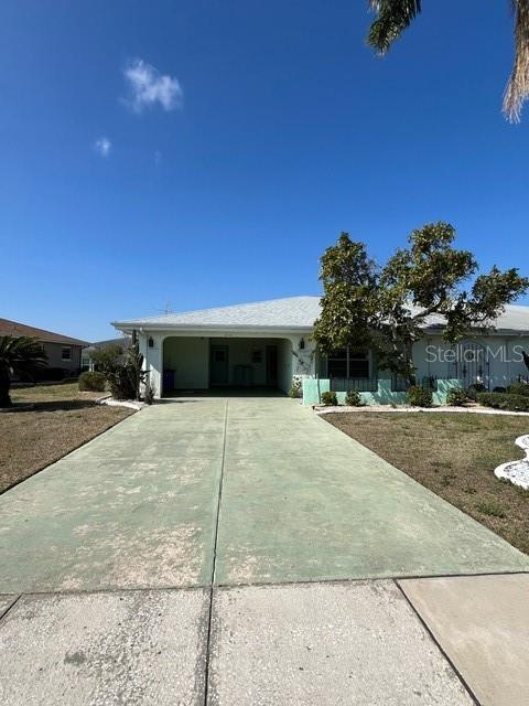 ranch-style house featuring an attached carport and driveway