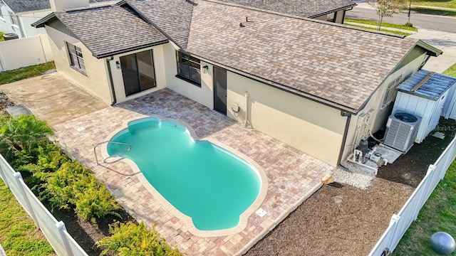 view of swimming pool featuring a patio, a fenced backyard, and central AC