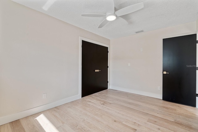 spare room featuring wood finished floors, ceiling fan, a textured ceiling, and baseboards