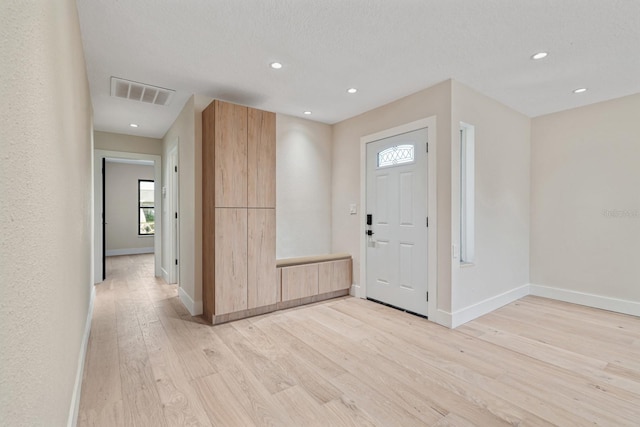 entryway with light wood finished floors, baseboards, and recessed lighting