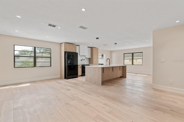 kitchen with black appliances, open floor plan, modern cabinets, plenty of natural light, and recessed lighting