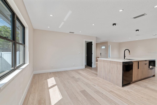 kitchen with dishwasher, a sink, light brown cabinetry, modern cabinets, and open floor plan