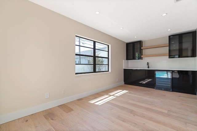 kitchen with wine cooler, baseboards, light wood finished floors, open shelves, and recessed lighting
