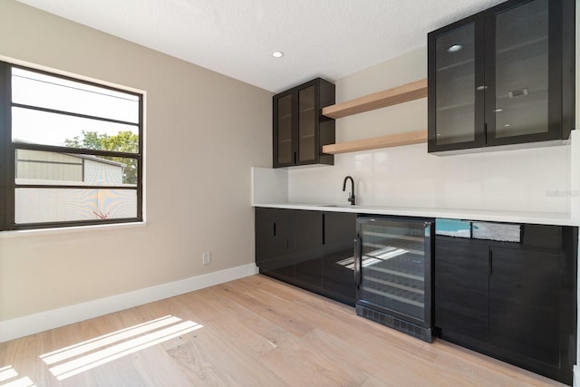 kitchen with beverage cooler, open shelves, baseboards, dark cabinetry, and recessed lighting
