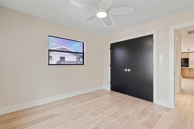 unfurnished bedroom with light wood finished floors, baseboards, and ceiling fan