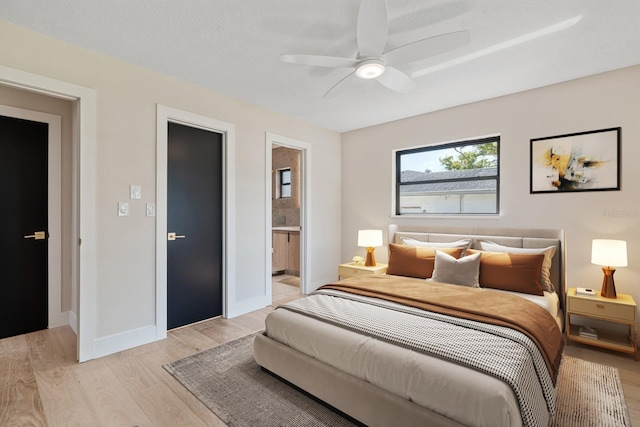 bedroom with light wood-type flooring, baseboards, ensuite bathroom, and a ceiling fan