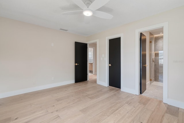 unfurnished bedroom featuring light wood finished floors, baseboards, a ceiling fan, and ensuite bathroom