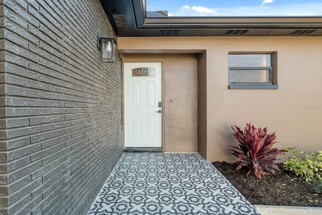 view of exterior entry featuring stucco siding
