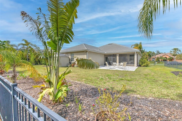 5409 Conch Shell Pl, Apollo Beach, FL 33572 - rear view of property featuring fence, a patio area, stucco siding, a lawn, and a sunroom