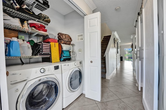 laundry area featuring washing machine and clothes dryer, light tile patterned flooring, baseboards, and laundry area