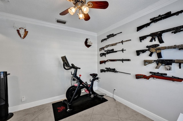 exercise room with light tile patterned flooring, a textured ceiling, visible vents, crown molding, and a ceiling fan