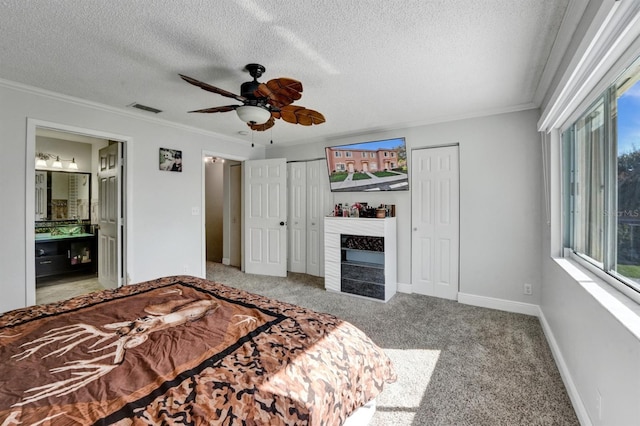 carpeted bedroom with baseboards, visible vents, ornamental molding, and a fireplace