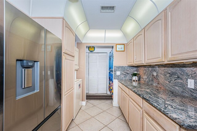 13000 Gulf Blvd Unit 109, Madeira Beach, FL 33708 - kitchen featuring light brown cabinets, stainless steel fridge, backsplash, light tile patterned flooring, and visible vents