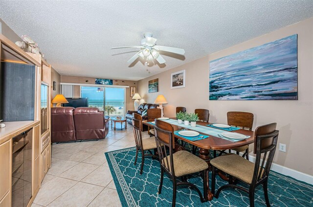13000 Gulf Blvd Unit 109, Madeira Beach, FL 33708 - dining area featuring light tile patterned floors, baseboards, a ceiling fan, a textured ceiling, and beverage cooler