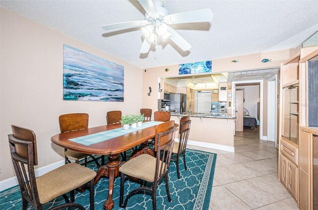 13000 Gulf Blvd Unit 109, Madeira Beach, FL 33708 - dining space with baseboards, a ceiling fan, light tile patterned flooring, and a textured ceiling