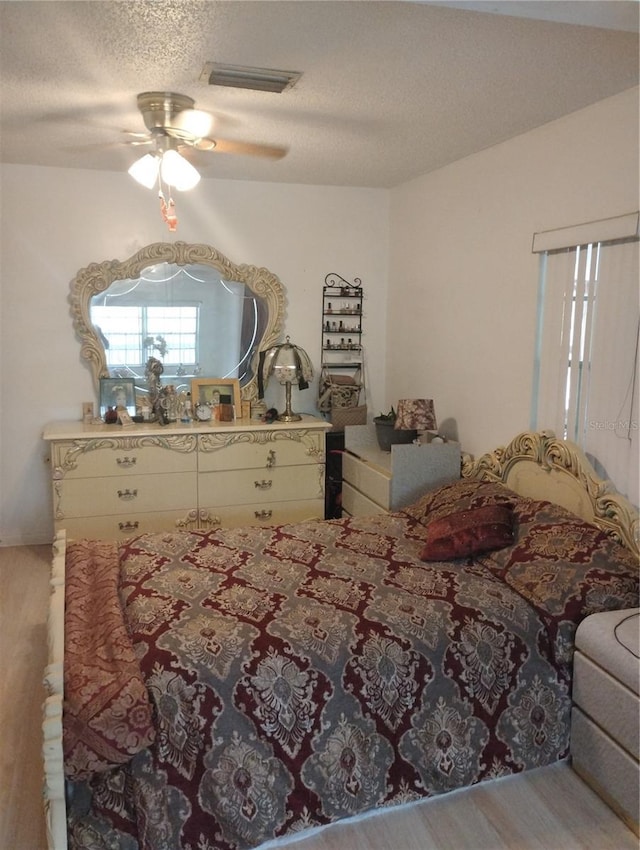 14633 Sassandra Dr, Odessa, FL 33556 - bedroom with vaulted ceiling, a textured ceiling, visible vents, ceiling fan, and wood finished floors