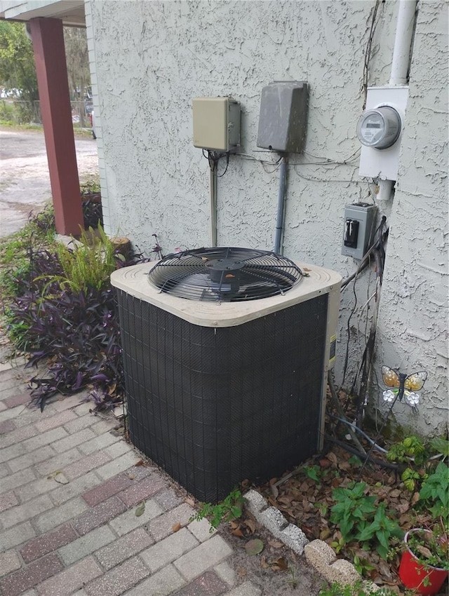 14633 Sassandra Dr, Odessa, FL 33556 - exterior details with electric meter, stucco siding, and central AC