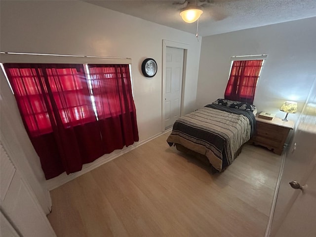 14633 Sassandra Dr, Odessa, FL 33556 - bedroom featuring light wood finished floors, a textured ceiling, and ceiling fan
