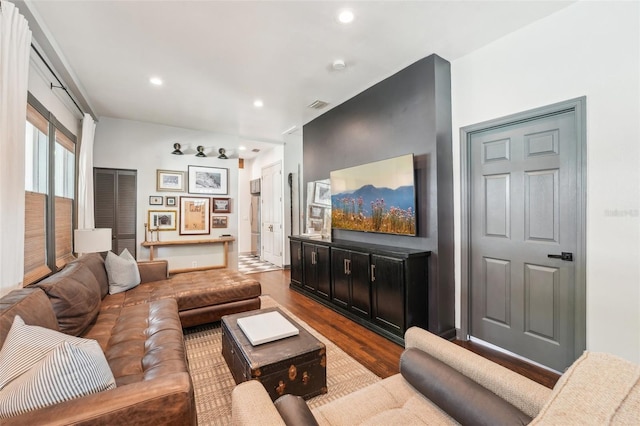 living area with baseboards, visible vents, wood finished floors, and recessed lighting