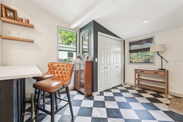 office with baseboards, vaulted ceiling, and dark floors